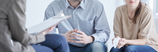 Conflicted husband and wife during session with divorce coach